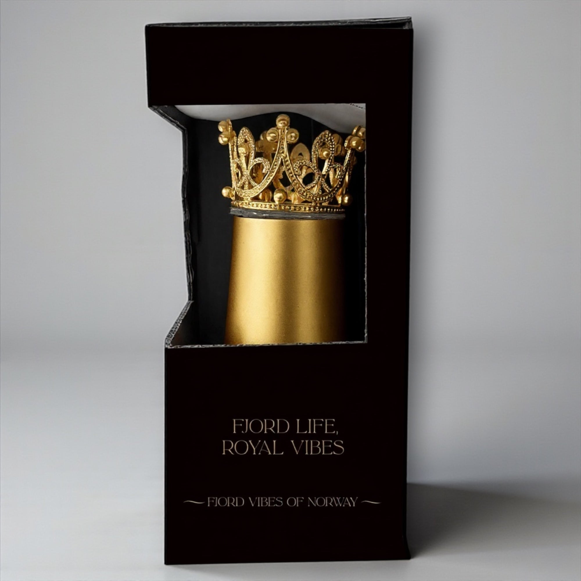 Bilde av en svart, elegant eske med vindu der en ser en prosecco kopp i gull med gull-krone inni. Av Fjord Vibes of Norway