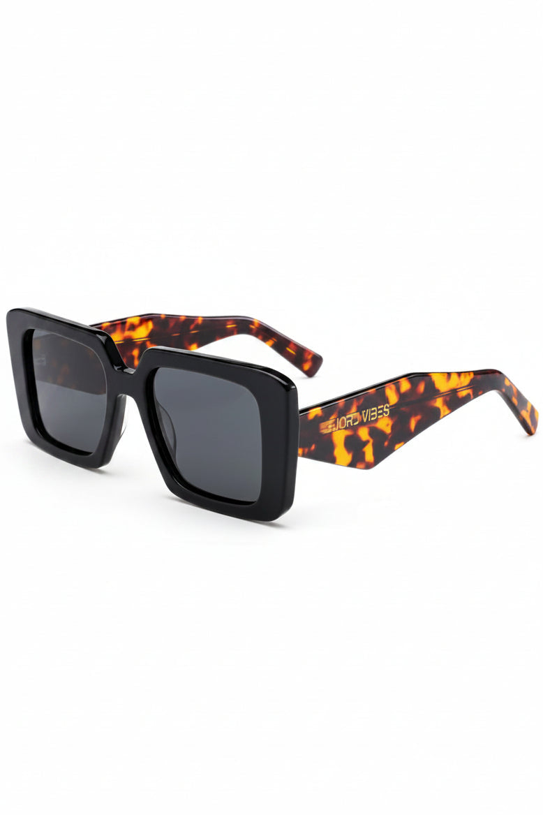 Oversized Acetate statement solbriller fra Fjord Vibes of Norway med svart rammme, svart innfatning og Amber turtoise  og brunfarget arm med hvit bakgrunn på bildet