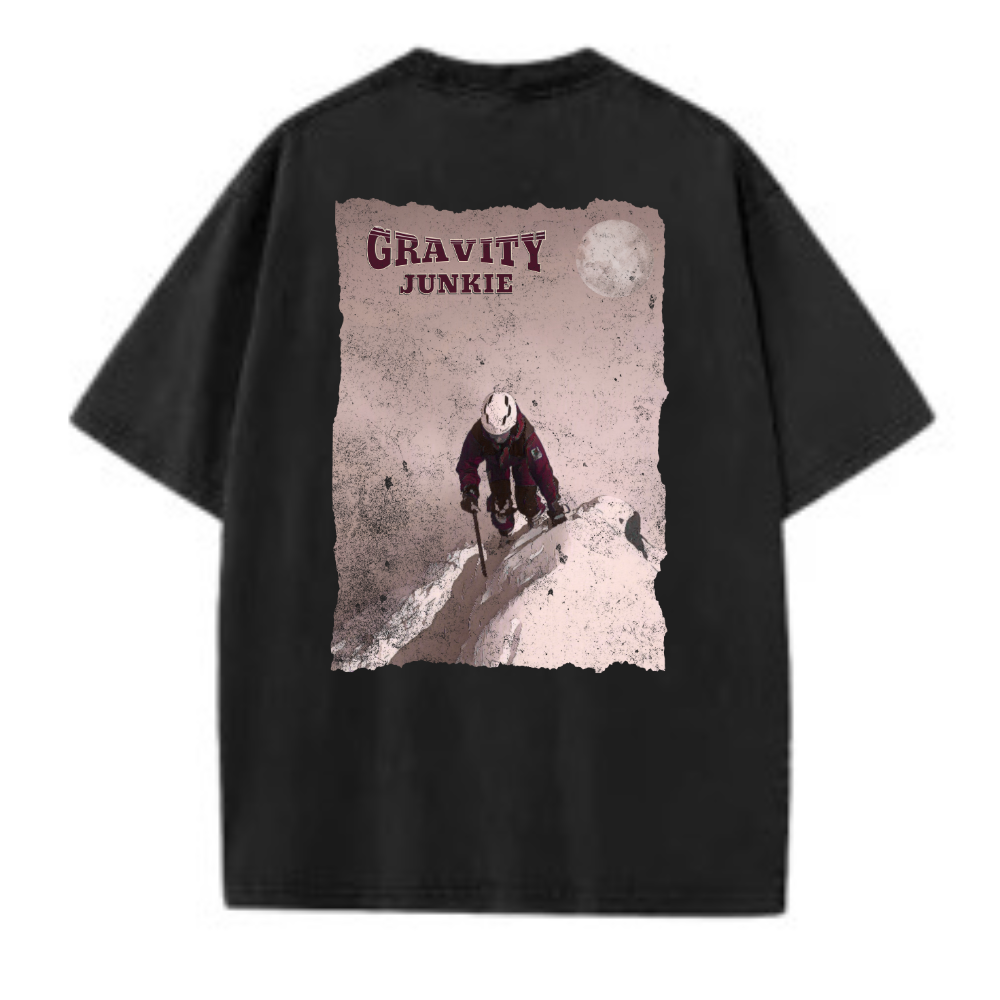 En t-skjorte i washed utførelse med bilde av en person som er på vei opp et fjell med stegjern og is-øks med teksten Graviy Junkie skrevet på ryggen. Mørk grå t-skjorte