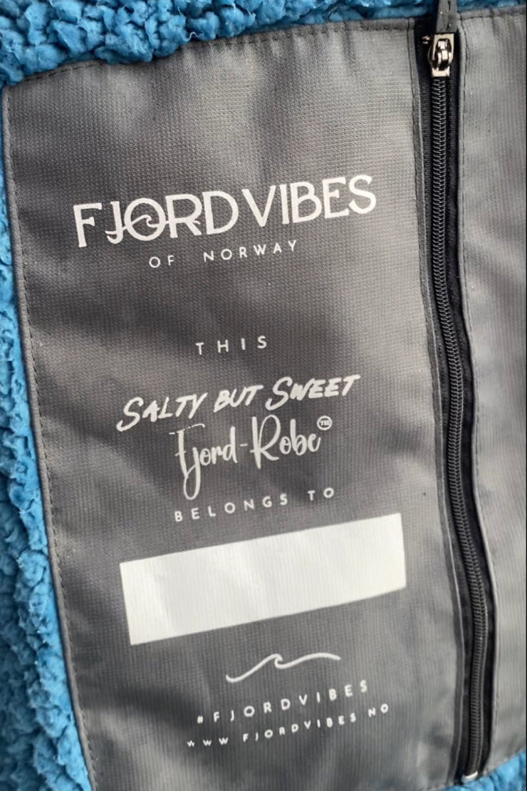 bilde av en innerlomme på badekåpen til FjordVibes of Norway ed blå teddy- fleece inni kåpen