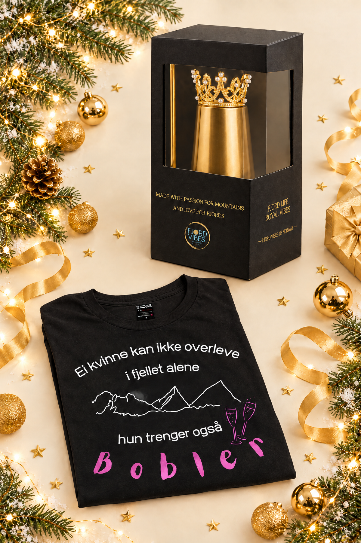 Julegavepakke fra Fjord Vibes: svart prosecco t-skjorte for dame med Til Fjells-trykk og proseccokopp i gull med krone i gaveeske, omgitt av julepynt i gull